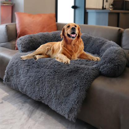 Golden Retriever relaxing on a grey plush pet sofa bed.