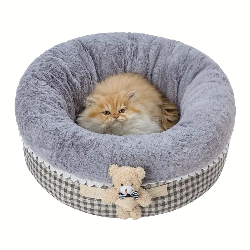 Plush round pet bed with teddy bear toy for cats.
