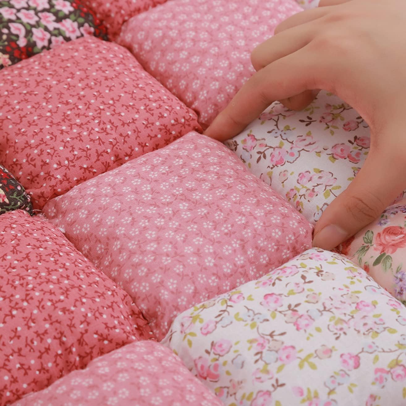 "Close-up showing the thickness and texture of the pink floral patchwork sofa cover."
