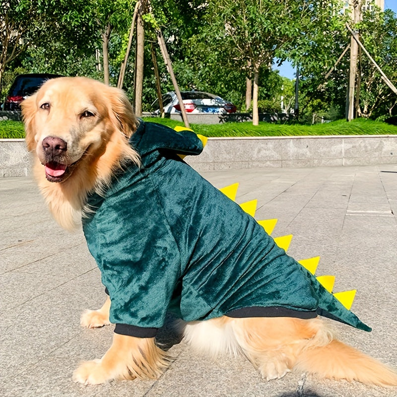 a golden retriever standing outdoors, wearing a dark green, dinosaur-themed fleece hoodie.