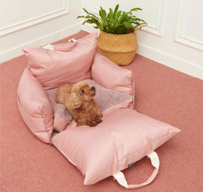 "Small dog resting in a pink fold-out travel bolster bed."
