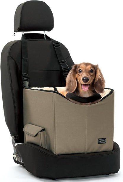 A small dog sitting upright in a tall, dark brown booster seat attached to a car's seat.