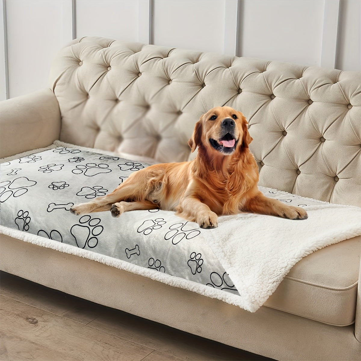 a happy golden retriever lying on a large pet bed with a paw and bone pattern.